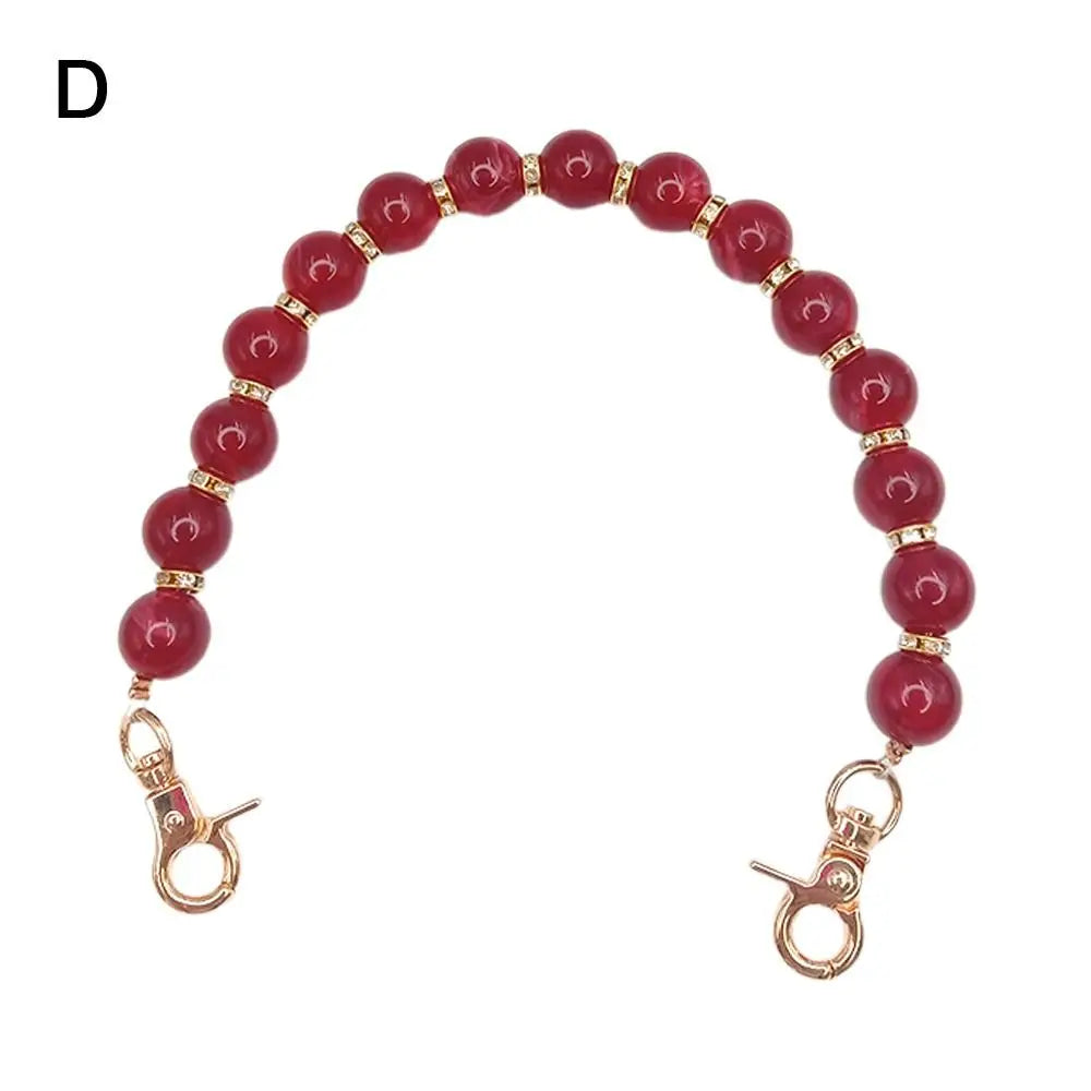 Handcrafted resin stone bead bag chain with round red beads and gold-toned clasps