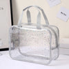 A clear waterproof makeup organizer bag with handles is displayed on a white surface.