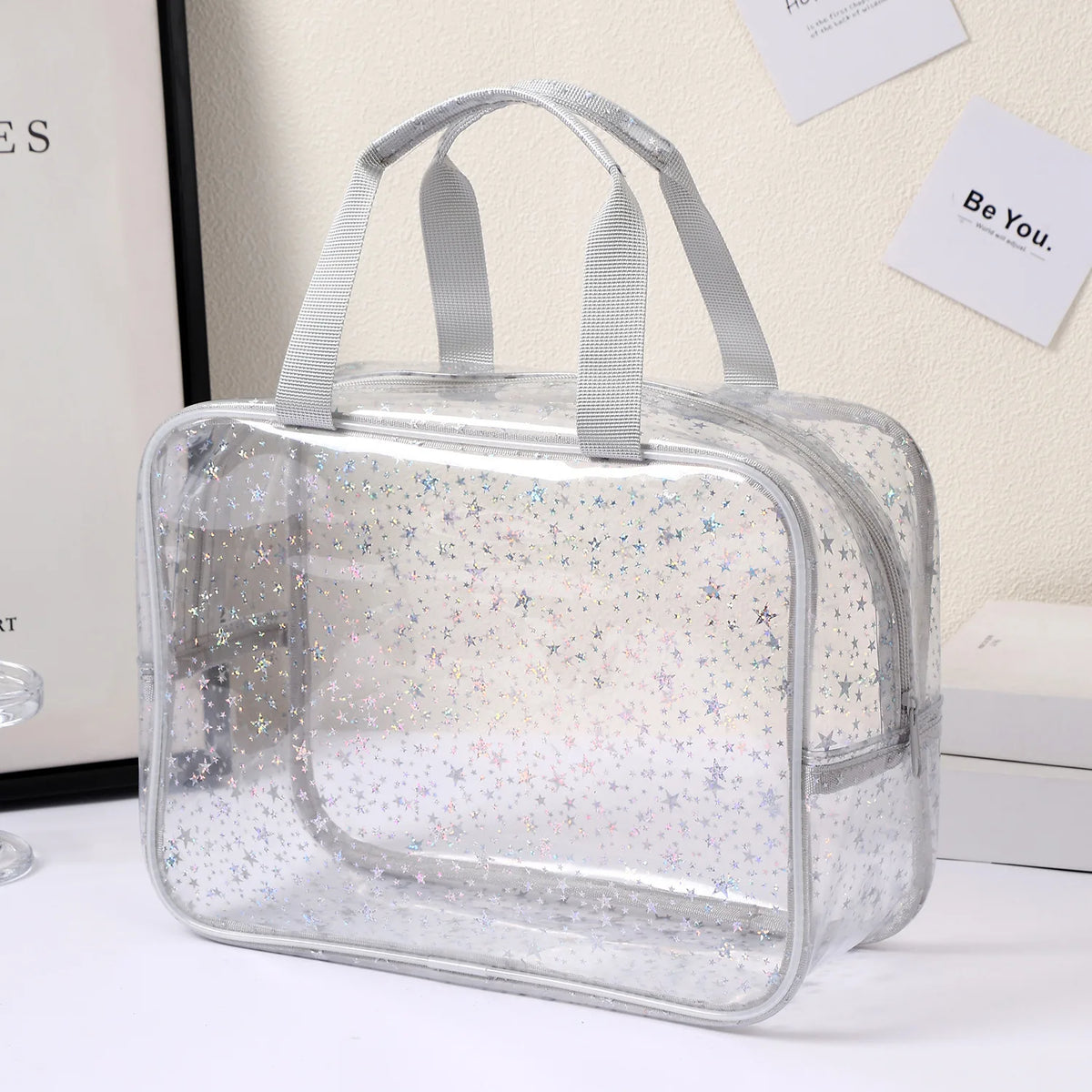A clear waterproof makeup organizer bag with handles is displayed on a white surface.