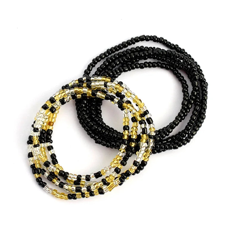 Several strands of black, gold, and clear beads for body jewelry.