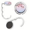 Silver bag hook with a round floral charm and a separate circular silver ring.