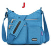 Blaue wasserdichte Nylon-Crossbodytasche mit schwarzem Riemen und Reißverschlussdetails.