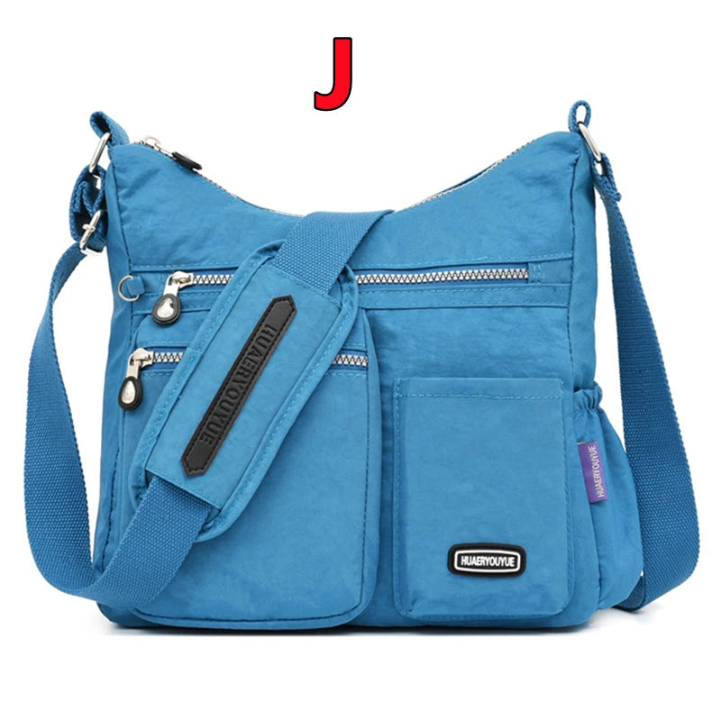 Blaue wasserdichte Nylon-Crossbodytasche mit schwarzem Riemen und Reißverschlussdetails.