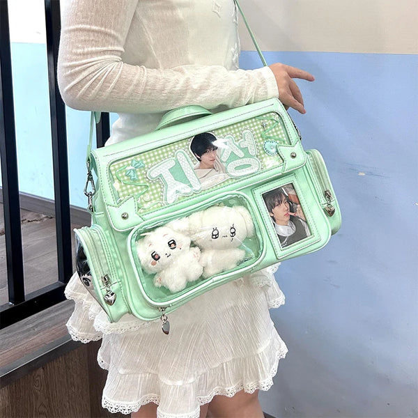 A light mint green Y2K transparent PU crossbody bag with a floral pattern and a white fluffy charm is being held by a person.