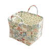 A quilted fabric storage basket with carry handles featuring a floral pattern in muted greens and reds.