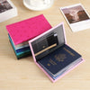 A pink leather passport cover with a heart print, open to reveal a passport and travel documents.
