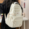 A white lightweight nylon college backpack is shown from the back, resting on a table.