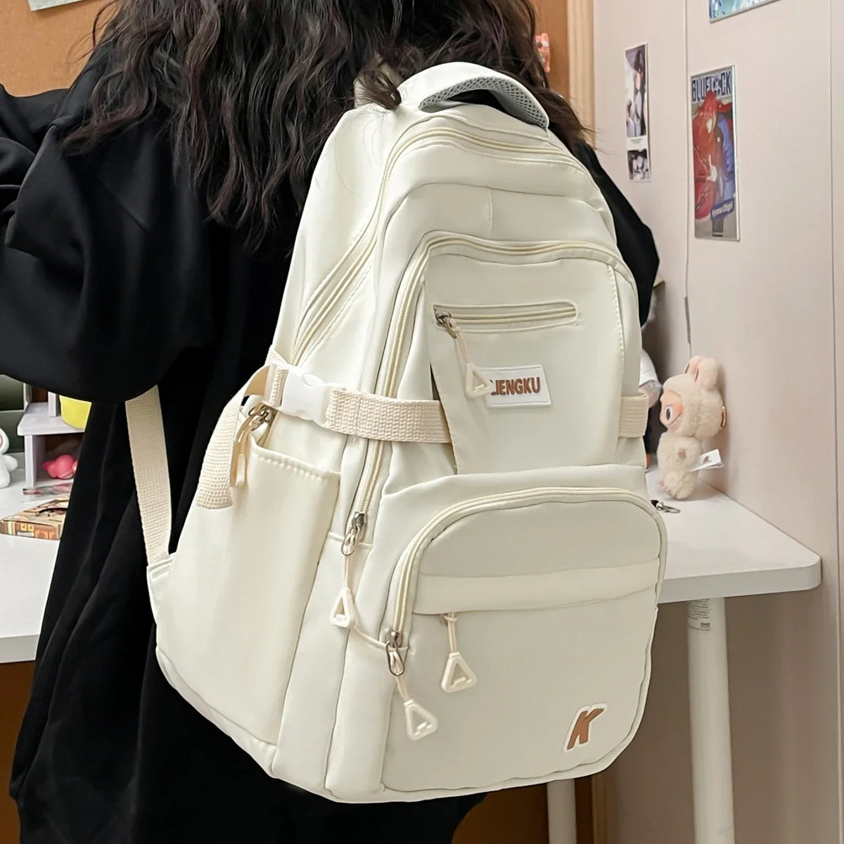 A white lightweight nylon college backpack is shown from the back, resting on a table.