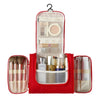 A red multi-compartment travel pouch with a floral print lining and a hanging loop, containing various cosmetic items.