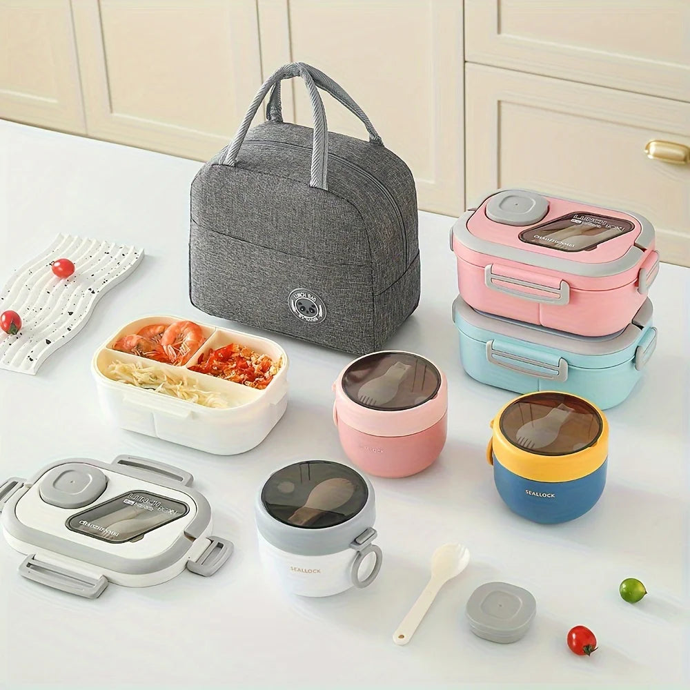 A 3-piece insulated lunch set featuring a gray bag, pink and blue food containers, and a silver food processor on a white sur