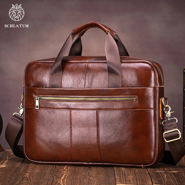 A brown genuine leather briefcase with padded straps and a zipper is shown on a wooden surface.
