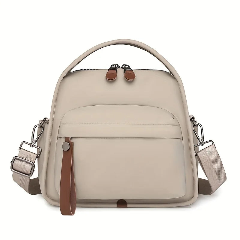 A beige multi-pocket shoulder crossbody bag with brown leather accents and a padded strap.