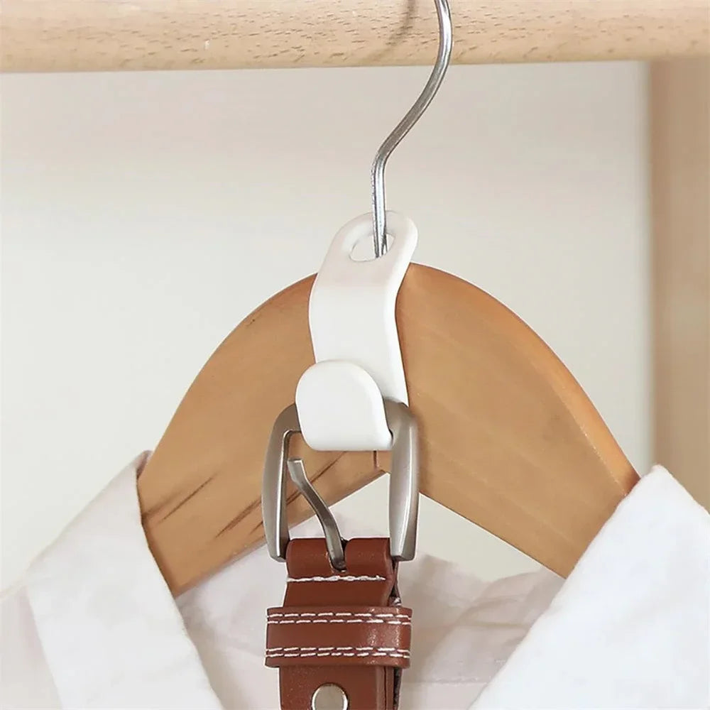 A multi-hook wardrobe organizer with white plastic hooks and a brown leather strap hanging from a wooden hanger.