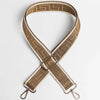 A tan leather adjustable crossbody bag strap featuring a woven maze pattern.