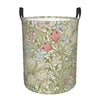 A vintage floral laundry hamper with a green and cream pattern, featuring large leaves and pink flowers.