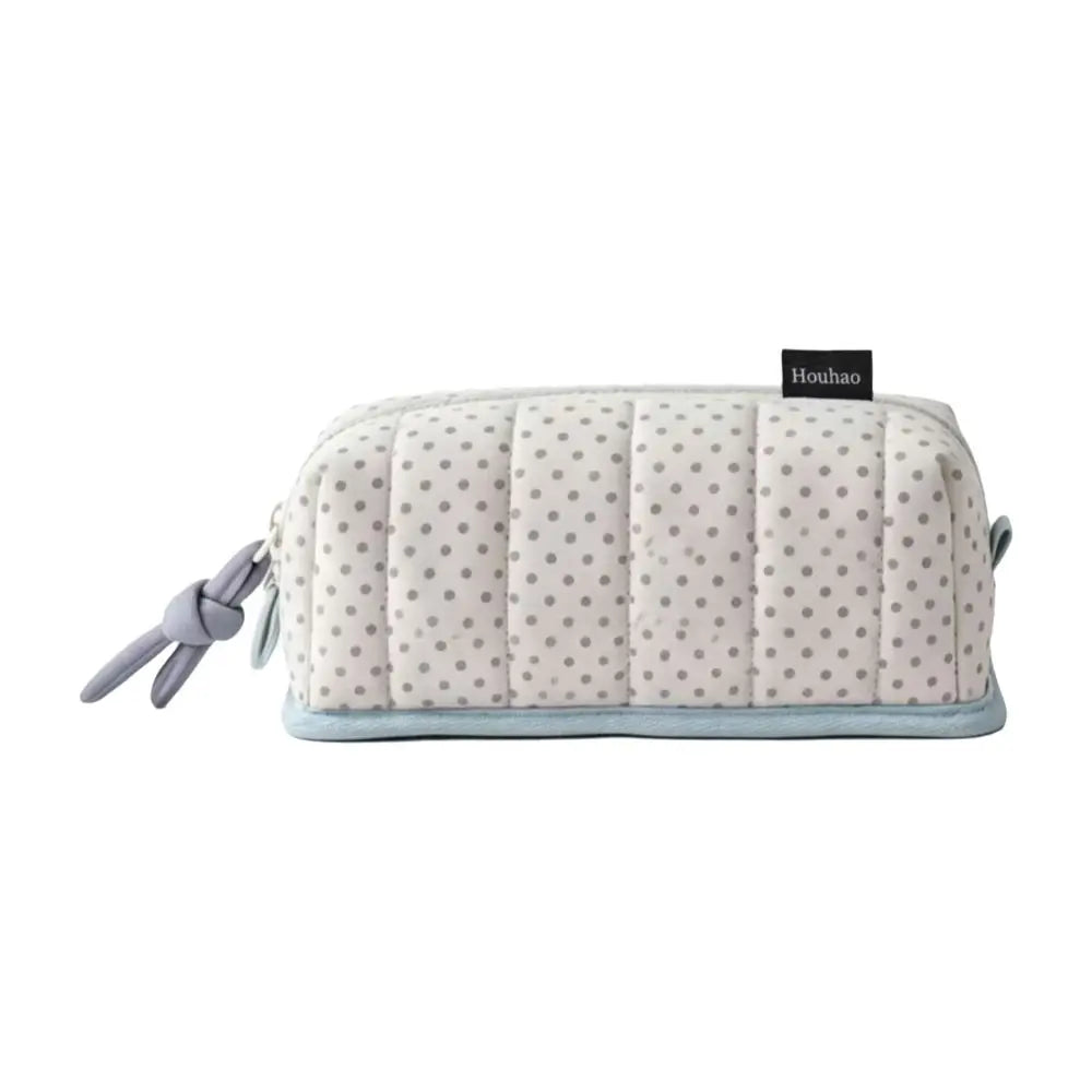 A light pink pencil case with a quilted texture and a gray dot pattern, featuring a light blue trim.