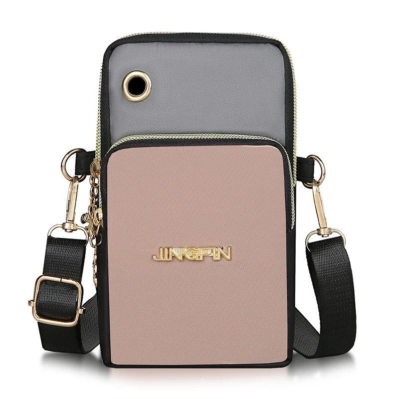 A light pink waterproof nylon crossbody bag with black trim and gold hardware.