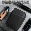 A black interlayer cache pocket organizer pouch is shown next to various tools and a chain on a gray background.