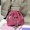 A pink crystal-embellished evening clutch with a silver chain is displayed against a light gray suit jacket.