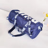 A navy blue Nike shoulder bag with white stripes lying on a white surface.