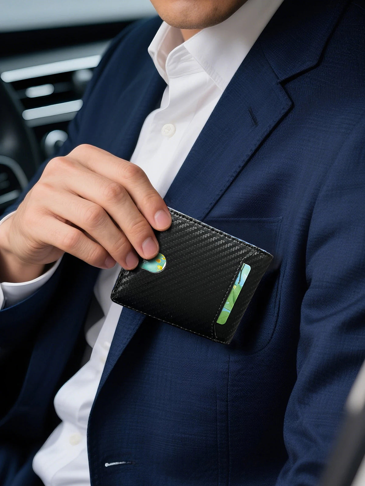 A hand is holding a black bi-fold leather wallet with a green accent, partially inside a navy blue suit jacket.