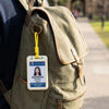 A university student's ID card with a photo and name is attached to a brown canvas backpack.