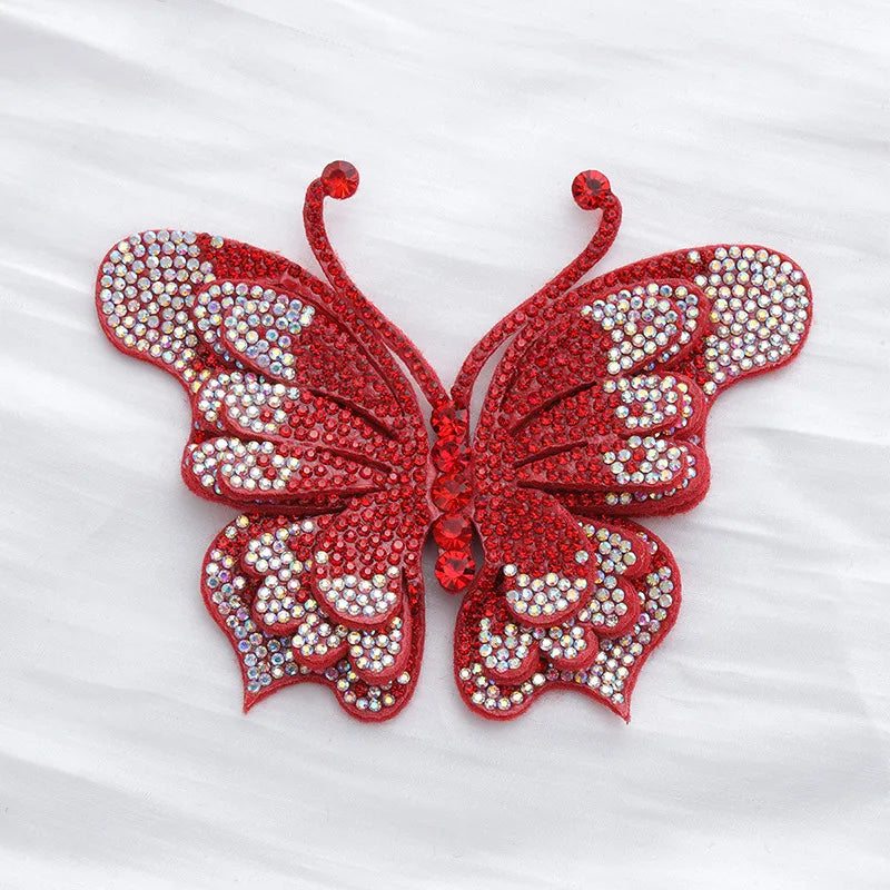 A vibrant red butterfly made of sparkling rhinestones and fabric applique.