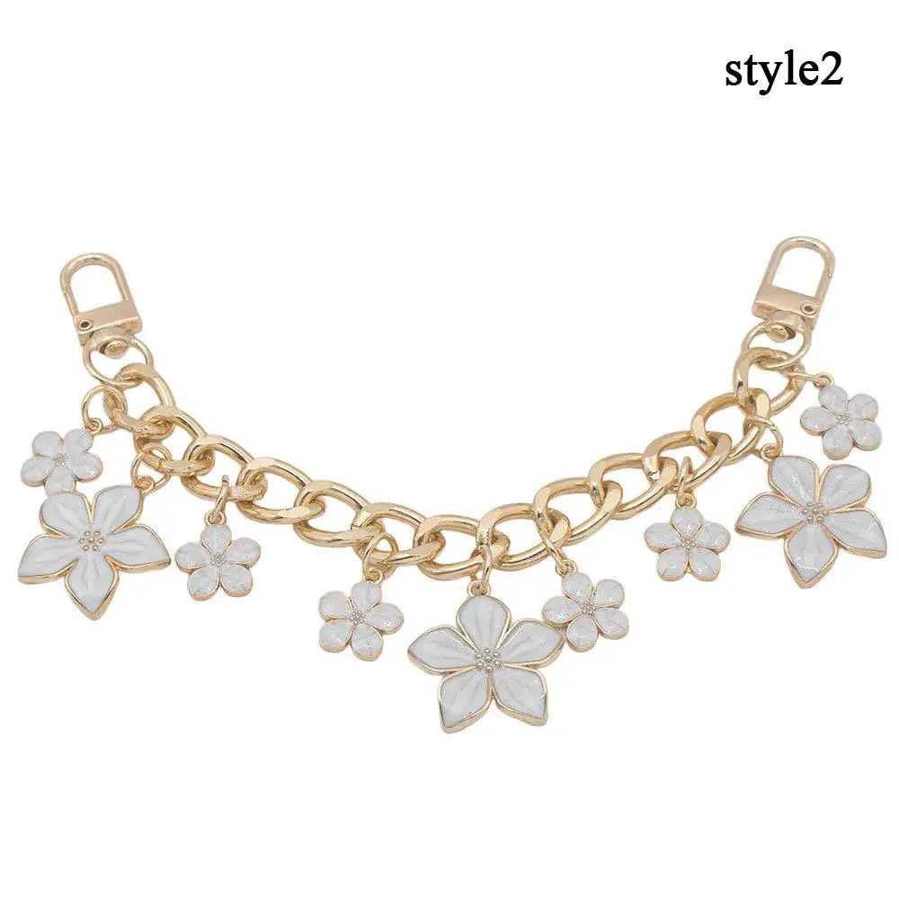 Accesorio de bolso dorado con cadena y charms de corazón y flor de cerezo