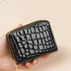 A black crocodile print fashion PU leather double zipper wallet being held in a hand.