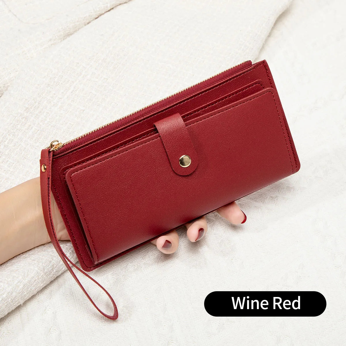 A deep wine red elegant PU leather coin purse and card holder resting on a white textured surface.