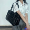 A woman holds a black Japanese style student messenger bag made of waterproof PU leather.