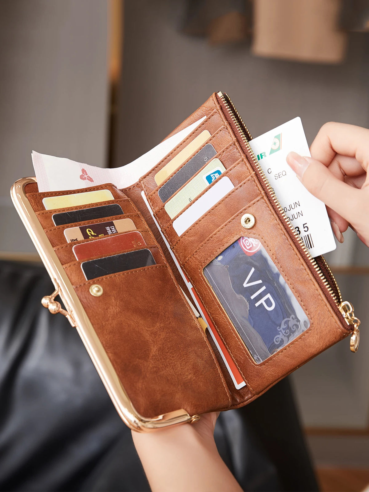 Braunes, altes Leder-Geldbörsen-Portemonnaie, geöffnet und mit Kreditkarten und Ausweis gefüllt.