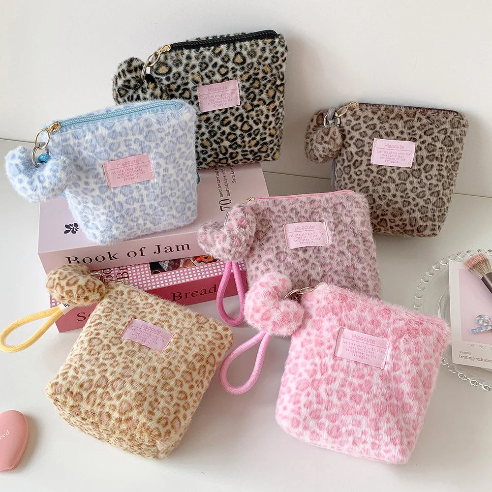 A collection of pink, beige, and leopard print makeup bags and skincare organizers displayed on a white surface.