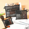 A collection of black mesh cosmetic storage pouches and brushes displayed on a light background.
