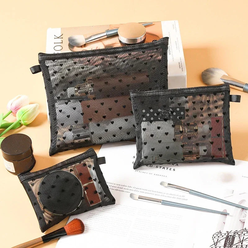 A collection of black mesh cosmetic storage pouches and brushes displayed on a light background.