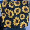 Black canvas tote bag featuring a vibrant yellow sunflower print.