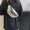 A person wearing a black shirt has a beige nylon waist bag slung across their back.
