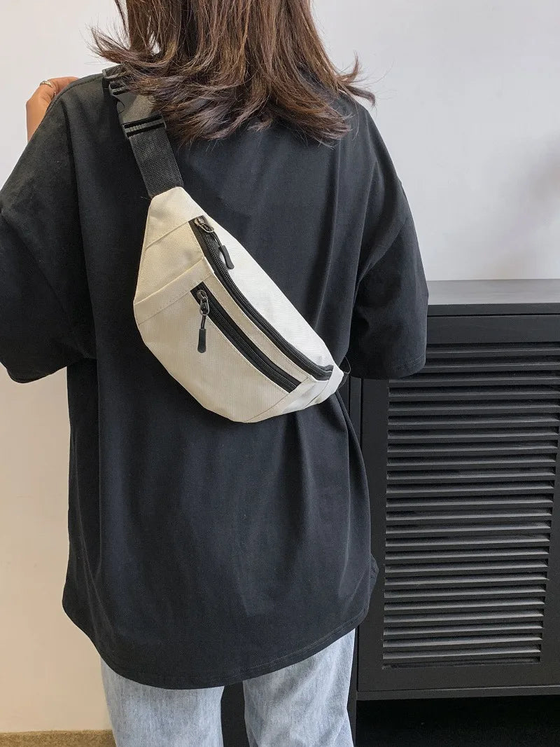 A person wearing a black shirt has a beige nylon waist bag slung across their back.