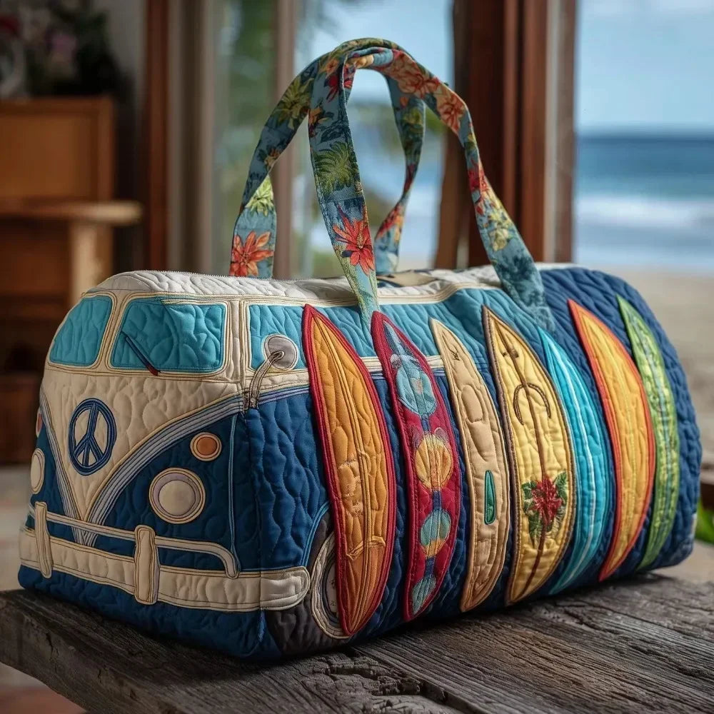 A quilted travel duffle bag featuring a blue and gold floral pattern with green straps, resting on a wooden surface.