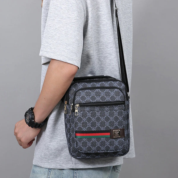 A gray t-shirt sleeve shows a black and gray versatile men's crossbody sling bag with a checkered pattern and red, green, and