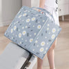 Light blue blanket storage bags with a white floral pattern are shown next to a white storage bin.