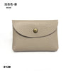 A beige genuine leather card holder or coin purse with a gold-toned stud closure.