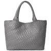 A gray handwoven vegan leather tote bag with a woven texture.