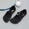 Black women's barefoot five-toe shoes with an adjustable strap and a baseball nearby.