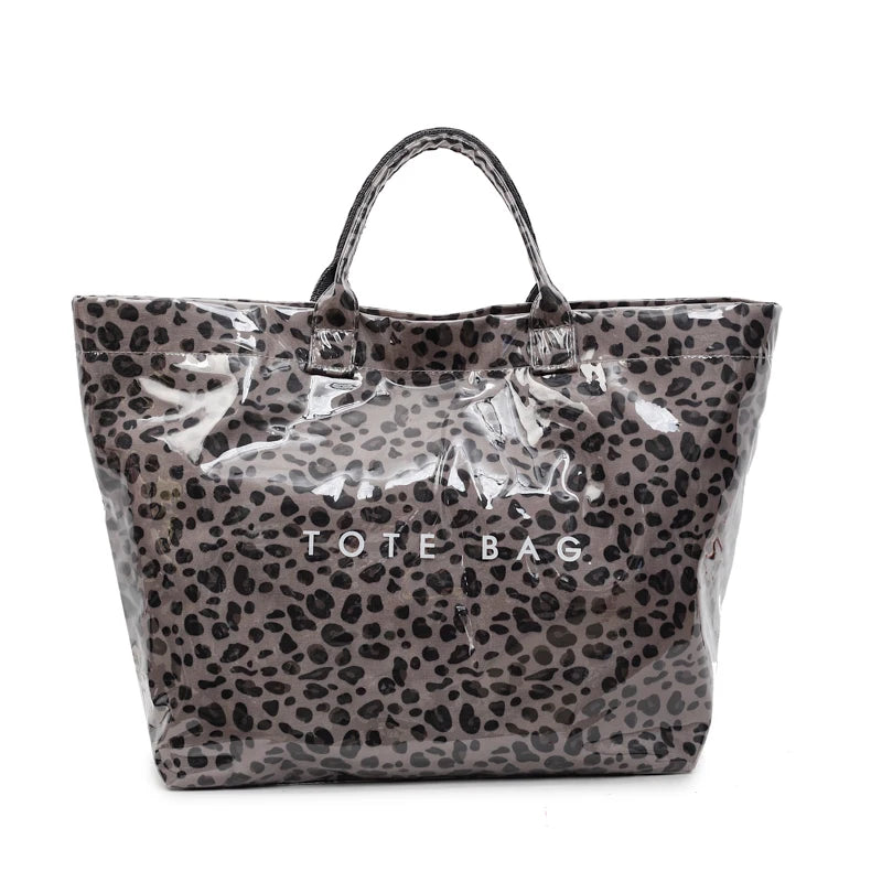 Graue Leopardenmuster-PVC-Tasche mit klarem Kunststofffutter und Henkel.