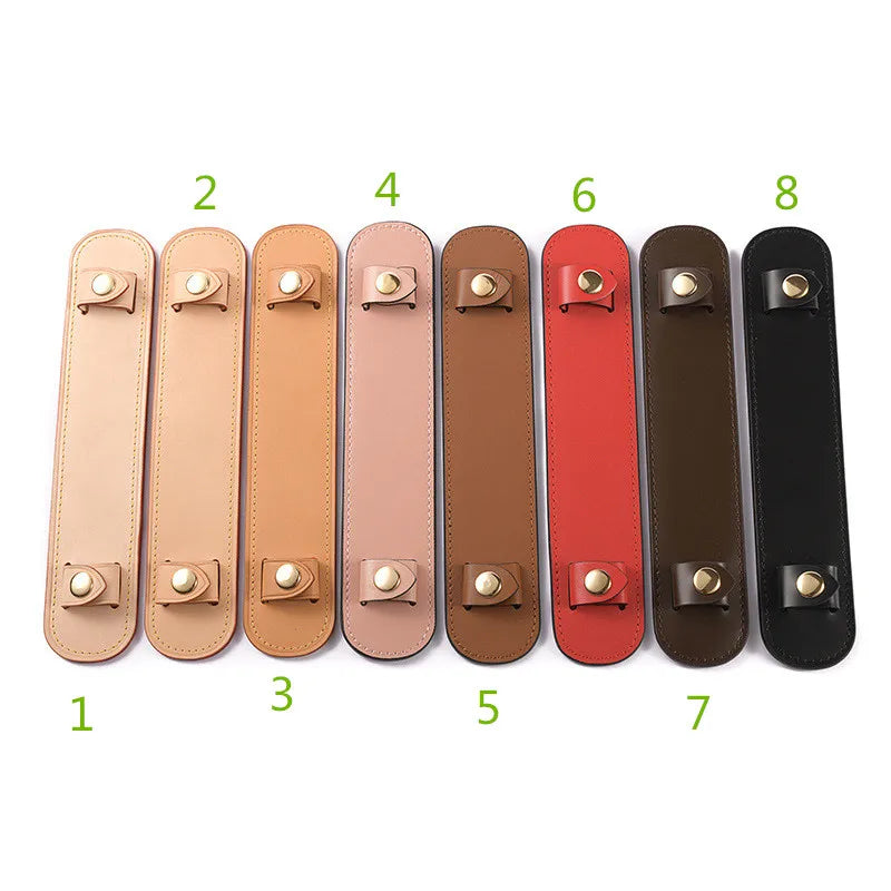 A row of eight leather handbag carry loops in various shades of tan, pink, brown, and black.