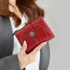 A close-up of a red leather RFID anti-theft multi-card wallet being held by a woman.