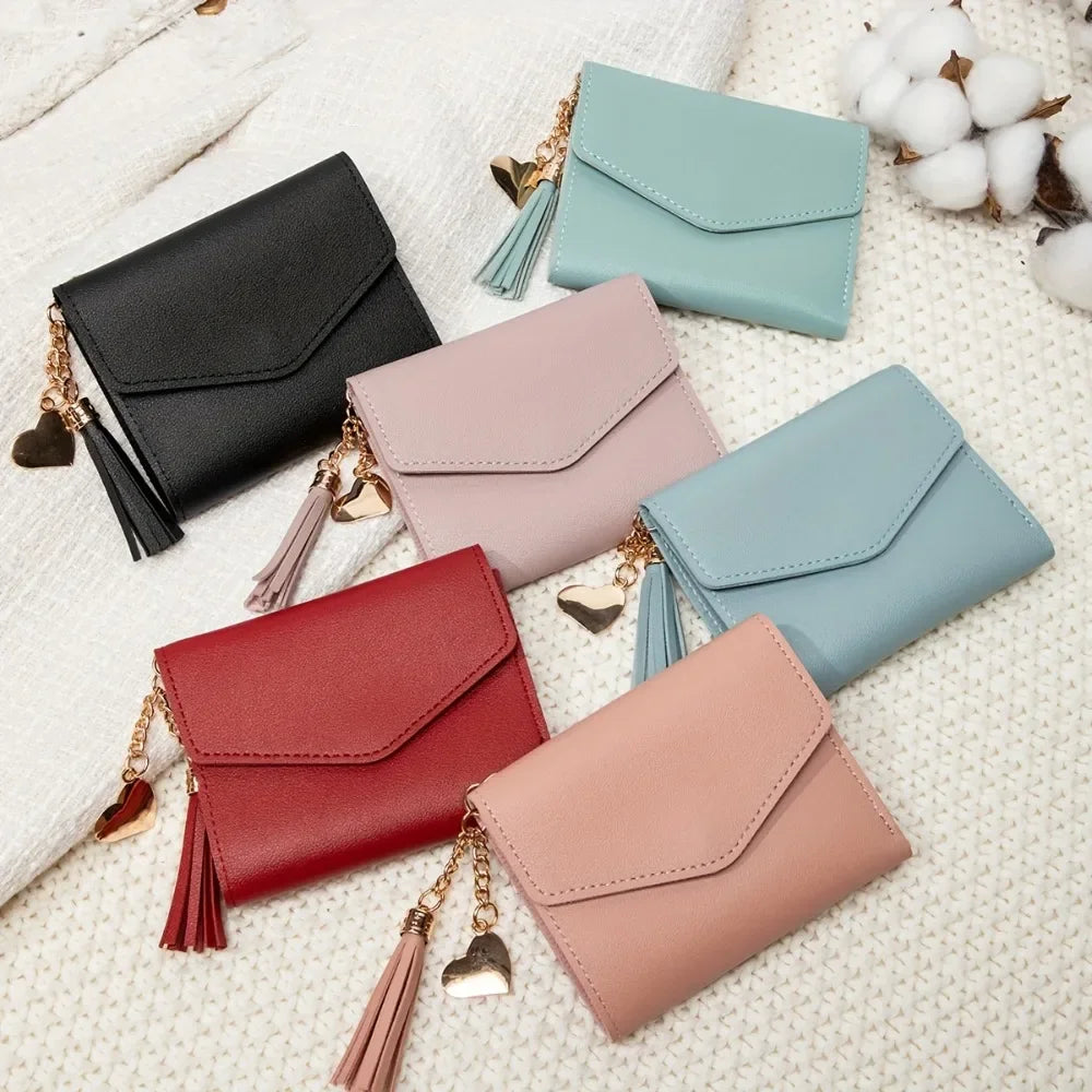 A collection of five PU leather women's coin clutch wallets in shades of black, mint green, pink, and blue, displayed on a wh