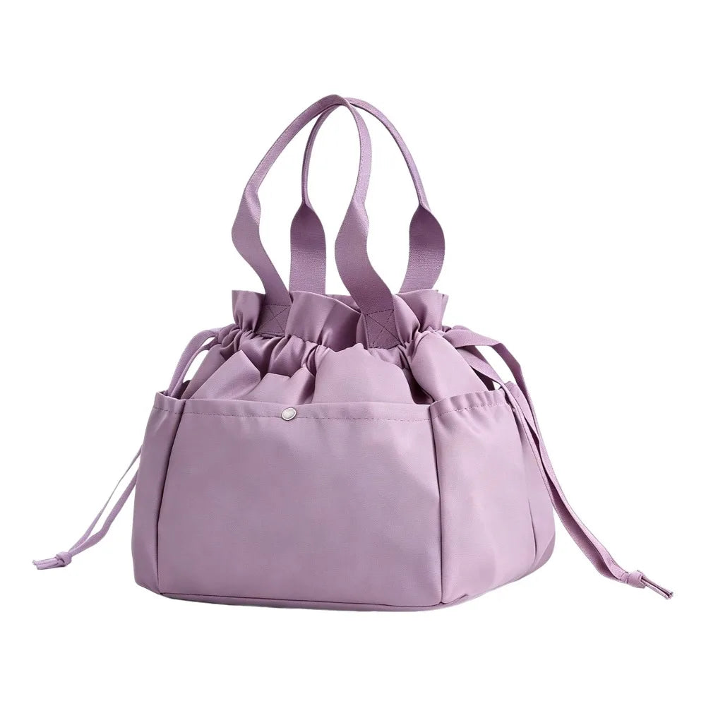 A light purple insulated drawstring lunch bag with multiple pockets and fabric handles.