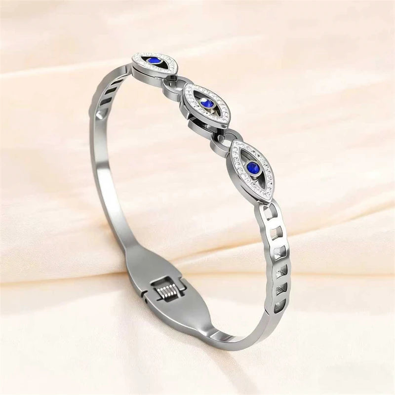 Silver cuff bracelet featuring blue stones and diamond accents on a light fabric background